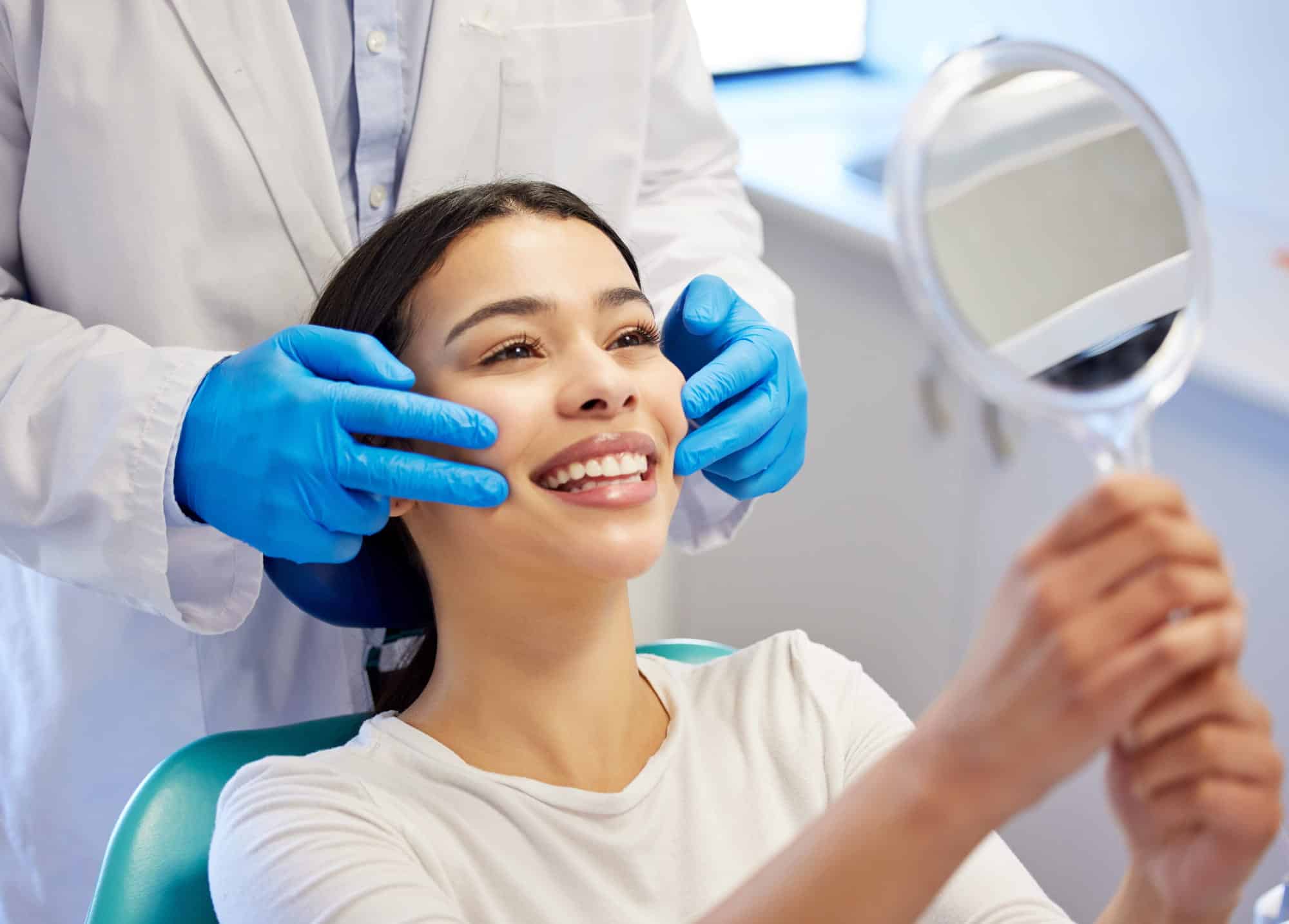 Cosmetic dentistry patient checking her smile at Rose City Dental in Windsor